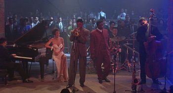 Movie still from “Mo' Better Blues” (1990), directed by Spike Lee – A group of men and a woman on a stage with musical instruments; Extreme Wide shot, High angle