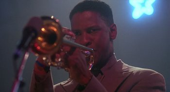 Movie still from “Mo' Better Blues” (1990), directed by Spike Lee – A man holding a trumpet while wearing a suit and tie; Close Up shot, Low angle