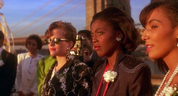 Movie still from “Mo' Better Blues” (1990), directed by Spike Lee – Two women standing next to each other in front of a bridge; Close Up shot, Low angle
