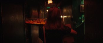 Movie still from “Molly's Game” (2017), directed by Aaron Sorkin – A woman sitting at a table in front of food; Medium shot, Over the shoulder angle