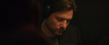 Movie still from “Molly's Game” (2017), directed by Aaron Sorkin – A person wearing headphones; Close Up shot, Over the shoulder angle