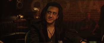 Movie still from “Molly's Game” (2017), directed by Aaron Sorkin – A man sitting at a table in a dark room; Close Up shot, Over the shoulder angle