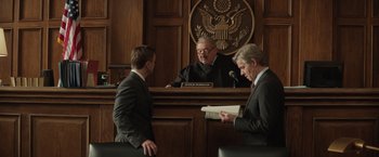Movie still from “Molly's Game” (2017), directed by Aaron Sorkin – Two men in suits stand in front of a judge; Medium shot, Low angle