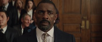 Movie still from “Molly's Game” (2017), directed by Aaron Sorkin – A person wearing a suit and tie; Close Up shot, Over the shoulder angle