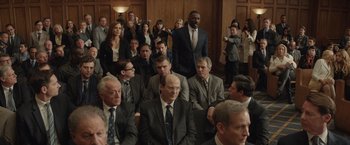 Movie still from “Molly's Game” (2017), directed by Aaron Sorkin – A group of people in suits and ties sitting in a room; Wide shot, High angle