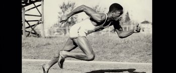 Movie still from “Molly's Game” (2017), directed by Aaron Sorkin – A man running on a dirt field with trees in the background; Medium shot, High angle