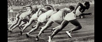 Movie still from “Molly's Game” (2017), directed by Aaron Sorkin – A black and white photo of a group of men running a race; Medium shot, High angle