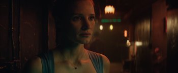 Movie still from “Molly's Game” (2017), directed by Aaron Sorkin – A woman with a necklace is standing in the dark; Close Up shot, Over the shoulder angle