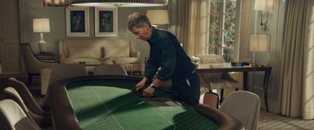 Movie still from “Molly's Game” (2017), directed by Aaron Sorkin – A man in a room with a large green table; Wide shot, High angle