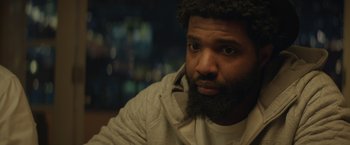 Movie still from “Molly's Game” (2017), directed by Aaron Sorkin – A person with a beard looking at the camera; Close Up shot, Over the shoulder angle