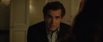 Movie still from “Molly's Game” (2017), directed by Aaron Sorkin – A person wearing a suit and tie; Close Up shot, Over the shoulder angle