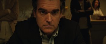 Movie still from “Molly's Game” (2017), directed by Aaron Sorkin – A person wearing a suit and tie; Close Up shot, Over the shoulder angle