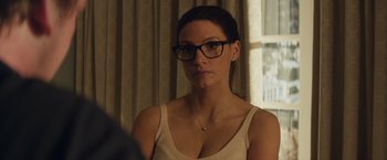 Movie still from “Molly's Game” (2017), directed by Aaron Sorkin – A woman wearing glasses looking at the camera; Close Up shot, Over the shoulder angle