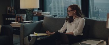 Movie still from “Molly's Game” (2017), directed by Aaron Sorkin – A woman sitting on a couch writing on a piece of paper; Medium shot, Over the shoulder angle