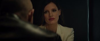 Movie still from “Molly's Game” (2017), directed by Aaron Sorkin – A woman looking into a mirror while wearing a white jacket; Close Up shot, Over the shoulder angle