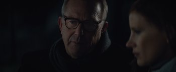Movie still from “Molly's Game” (2017), directed by Aaron Sorkin – An older man wearing glasses and a black jacket; Close Up shot, Over the shoulder angle