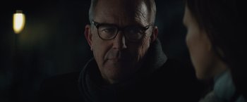 Movie still from “Molly's Game” (2017), directed by Aaron Sorkin – An older man wearing glasses and a black jacket; Close Up shot, Over the shoulder angle