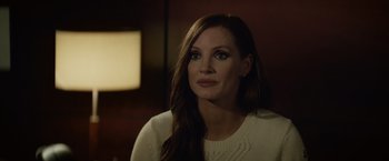 Movie still from “Molly's Game” (2017), directed by Aaron Sorkin – A woman in a white sweater looking to her left; Close Up shot, Over the shoulder angle