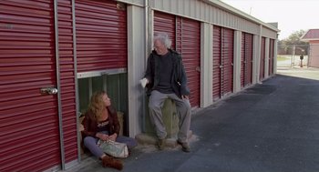 Movie still from “Monster” (2003), directed by Patty Jenkins – A man and a woman sitting on the side of a building next to each other; Wide shot, Low angle