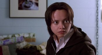 Movie still from “Monster” (2003), directed by Patty Jenkins – A young woman with brown hair wearing a brown jacket; Close Up shot, High angle