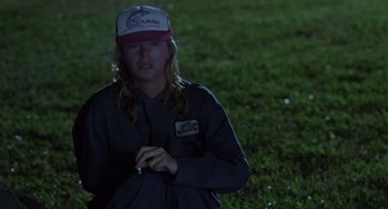 Movie still from “Monster” (2003), directed by Patty Jenkins – A person wearing a hat standing in the grass; Medium shot, Low angle