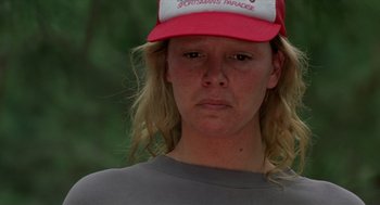 Movie still from “Monster” (2003), directed by Patty Jenkins – A woman wearing a red and white hat and a gray shirt; Close Up shot, Low angle
