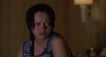 Movie still from “Monster” (2003), directed by Patty Jenkins – A woman in a blue apron is looking at the camera; Close Up shot, Over the shoulder angle