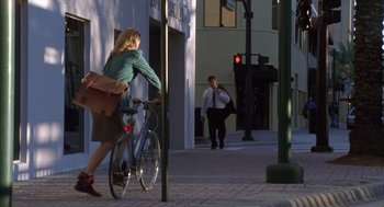 Movie still from “Monster” (2003), directed by Patty Jenkins – A woman is riding a bike down the street; Wide shot, Over the shoulder angle
