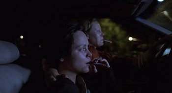 Movie still from “Monster” (2003), directed by Patty Jenkins – Two people sitting in the dark with one smoking a cigarette; Close Up shot, High angle
