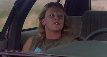 Movie still from “Monster” (2003), directed by Patty Jenkins – A woman sitting in the back seat of a car smoking a cigarette; Close Up shot, Low angle