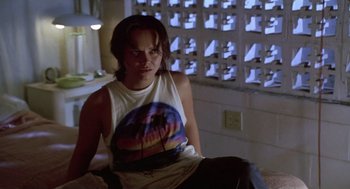 Movie still from “Monster” (2003), directed by Patty Jenkins – A person sitting in a room with a brick wall in the background; Medium shot, Over the shoulder angle