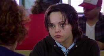Movie still from “Monster” (2003), directed by Patty Jenkins – A young woman sitting in front of a red wall; Close Up shot, Over the shoulder angle