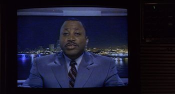 Movie still from “Monster” (2003), directed by Patty Jenkins – A man wearing a suit and tie in front of a river; Close Up shot, High angle