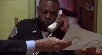 Movie still from “Monster” (2003), directed by Patty Jenkins – A man on a phone looking at a piece of paper; Close Up shot, Low angle