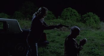 Movie still from “Monster” (2003), directed by Patty Jenkins – A man and a woman are standing in the dark with a gun; Medium shot, Over the shoulder angle