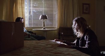 Movie still from “Monster” (2003), directed by Patty Jenkins – Two people sitting on a bed in front of a lamp; Wide shot, Low angle