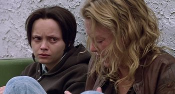 Movie still from “Monster” (2003), directed by Patty Jenkins – Two women sitting next to each other on the ground; Close Up shot, High angle