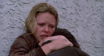 Movie still from “Monster” (2003), directed by Patty Jenkins – A woman holding a man in her arms and looking sad; Close Up shot, High angle