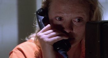 Movie still from “Monster” (2003), directed by Patty Jenkins – A woman is talking on the phone with her eyes wide open; Close Up shot, High angle