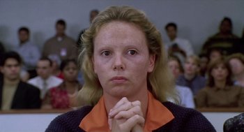 Movie still from “Monster” (2003), directed by Patty Jenkins – A woman with her hands clasped in front of a crowd; Close Up shot, High angle