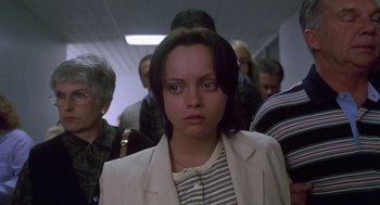 Movie still from “Monster” (2003), directed by Patty Jenkins – A woman in a white jacket standing in front of a group of people; Close Up shot, Low angle