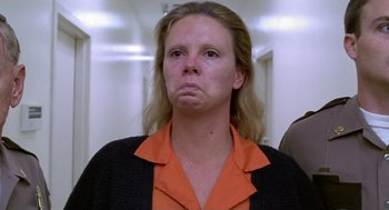 Movie still from “Monster” (2003), directed by Patty Jenkins – A woman in an orange shirt and a black jacket; Close Up shot, Low angle