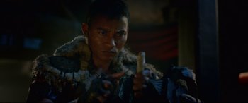 Movie still from “Monster Hunter” (2020), directed by Paul W.S. Anderson – A man holding a cell phone while wearing a fur coat; Close Up shot, Over the shoulder angle