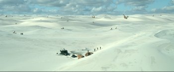 Movie still from “Monster Hunter” (2020), directed by Paul W.S. Anderson – A group of people standing on top of a snow covered slope; Extreme Wide shot, High angle
