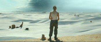 Movie still from “Monster Hunter” (2020), directed by Paul W.S. Anderson – A woman standing in the desert with a stack of rocks; Wide shot, High angle