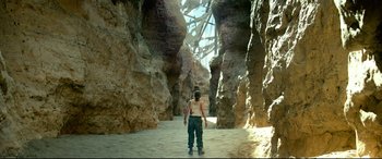 Movie still from “Monster Hunter” (2020), directed by Paul W.S. Anderson – A man is standing in the middle of a rock tunnel; Extreme Wide shot, High angle