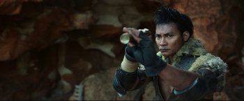 Movie still from “Monster Hunter” (2020), directed by Paul W.S. Anderson – A man in a leather jacket is holding a weapon; Close Up shot, Low angle