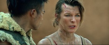 Movie still from “Monster Hunter” (2020), directed by Paul W.S. Anderson – A woman with a scar on her face and a man with a bandage on her head; Close Up shot, Over the shoulder angle