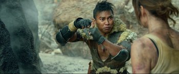 Movie still from “Monster Hunter” (2020), directed by Paul W.S. Anderson – A man in a leather jacket holds his fist up to his face; Close Up shot, Over the shoulder angle