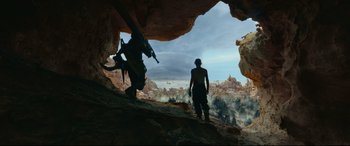 Movie still from “Monster Hunter” (2020), directed by Paul W.S. Anderson – A man standing on top of a mountain next to another man; Wide shot, Low angle